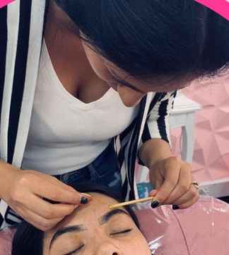 Profesional aplicando técnica de cejas a una clienta